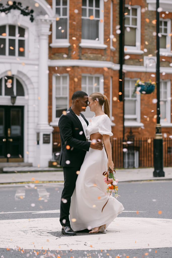 Modern couple posing for an editorial-style portrait in an urban London setting with confetti