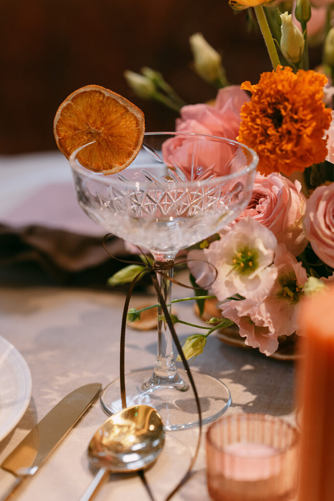 Champagne glass with floral arrangements in the background