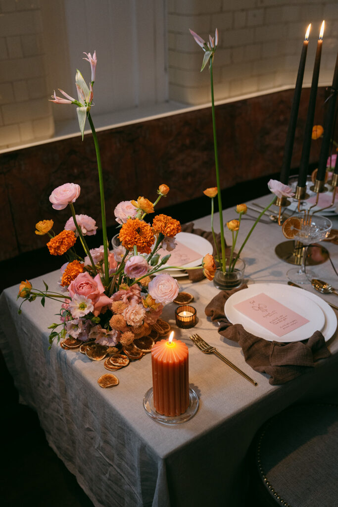 Colorful floral arrangements at wedding table with lighted candle