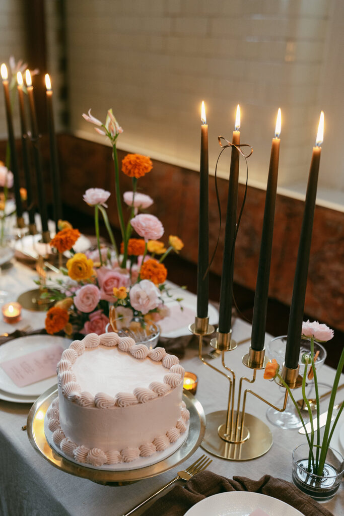 Editorial wedding dinner table with heart shaped chocolate cake and tall long black candles