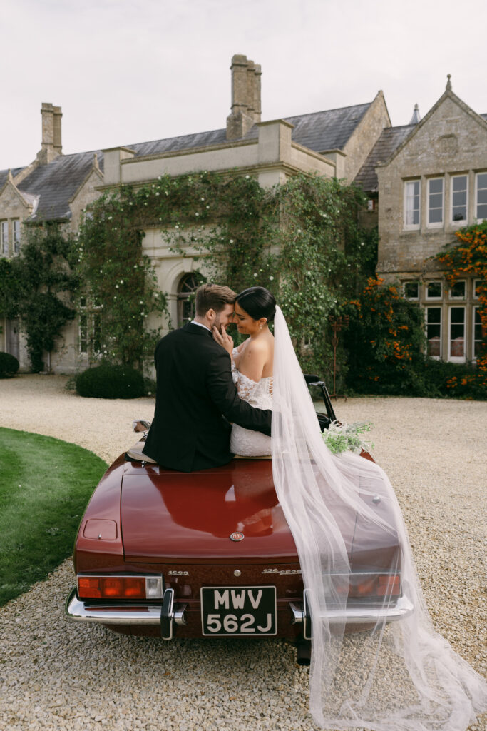 Newlyweds sitting on top of a car at Euridge Orangery Weddings