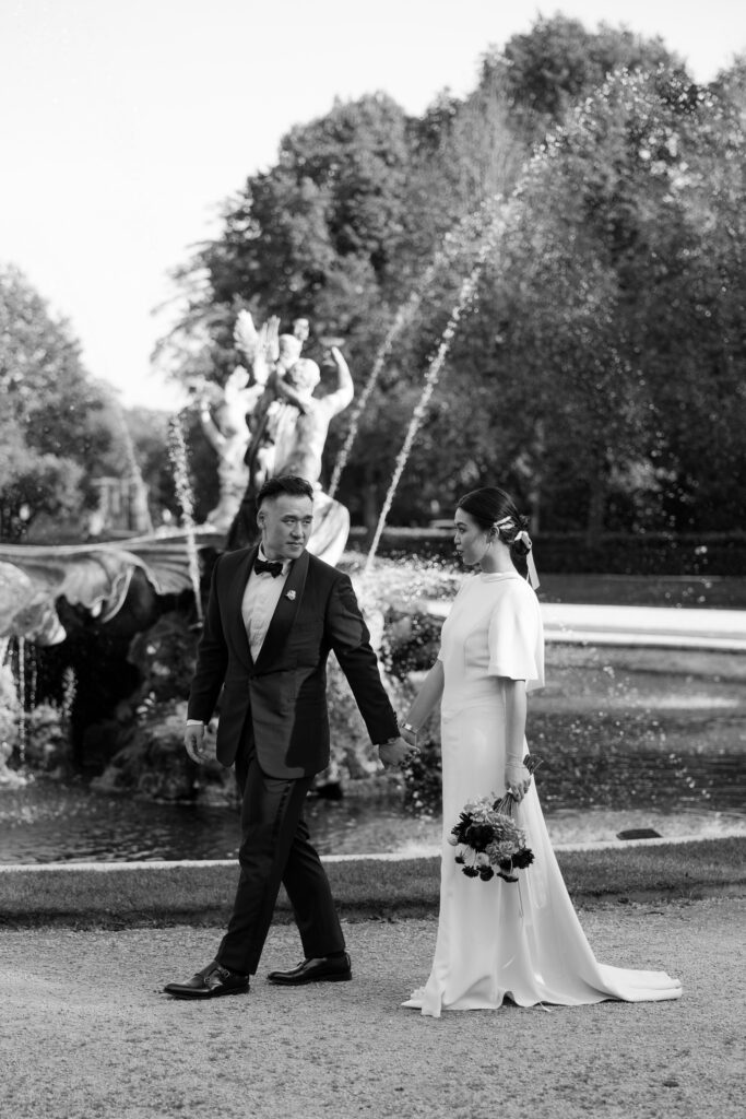 Bride and groom holding hands in a black and white photo