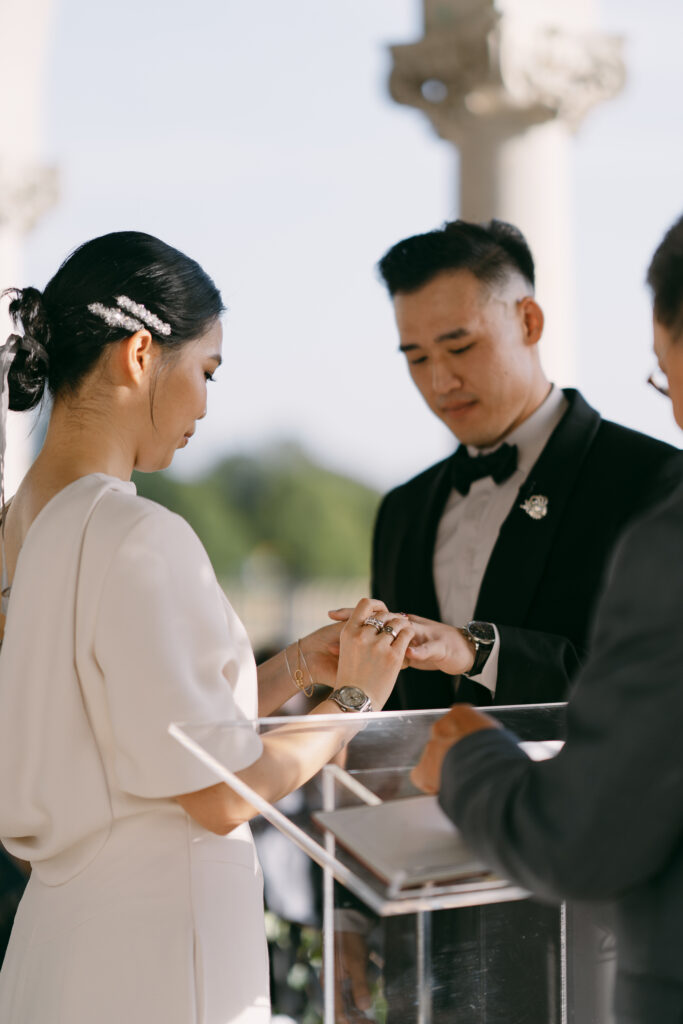 Bride putting ring on groom at Cliveden House's wedding altar
