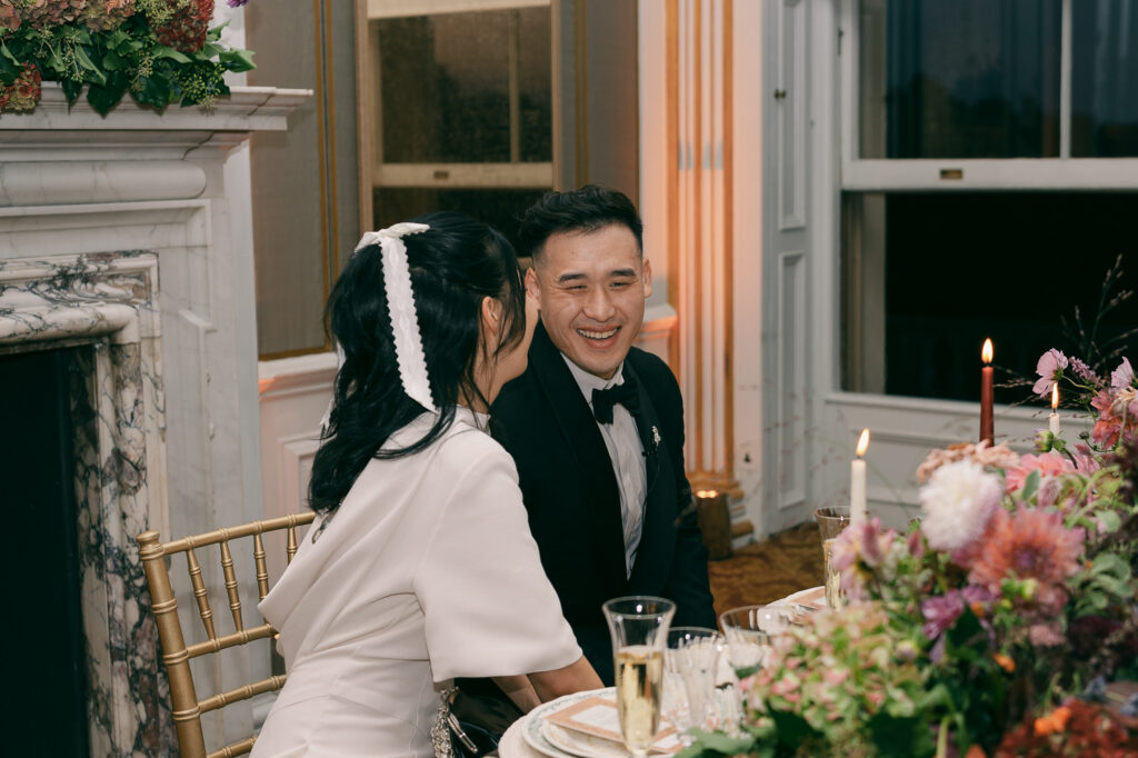 Newlyweds at dinner table smiling and laughing at Cliveden House