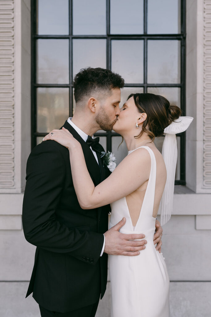 romantic shot of the bride and groom's attire as they kiss